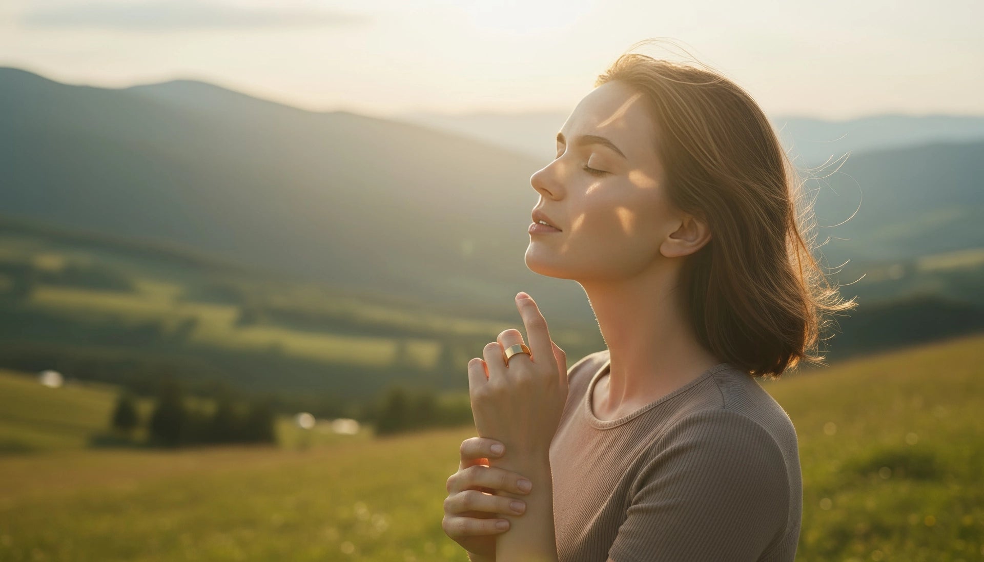 Smiling woman standing on the grass wearing a gold Omlezo Copper Magnetic Ring